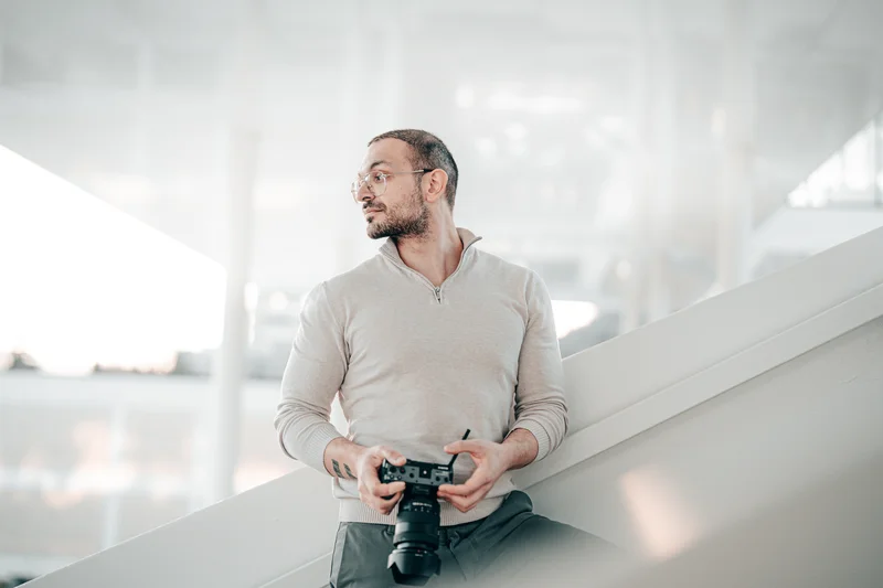 RawmanPictures - Sebastian Schiefermayr | Fotowalk Burhan | Fotograf im modernen Raum mit Kamera, bereit für kreative Aufnahmen. Perfekte Lichtnutzung.