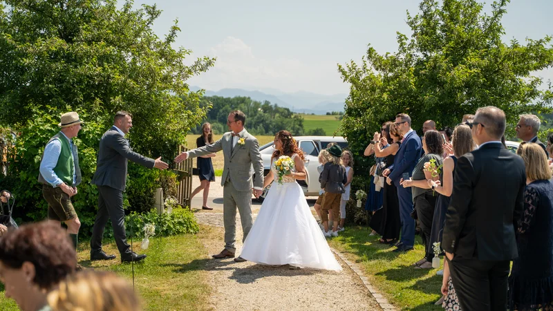 RawmanPictures - Sebastian Schiefermayr | Hochzeit Traude & Gerhard | Romantische Hochzeitsfotografie im Freien mit Brautpaar und Gästen in idyllischer Landschaft.