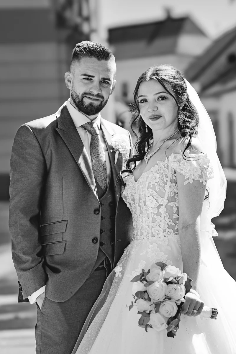 RawmanPictures - Sebastian Schiefermayr | Hochzeit Natalia & Jürgen | Elegante Hochzeitsfotografie: Brautpaar im Freien mit Blumenstrauß in stilvollem Schwarz-Weiß.