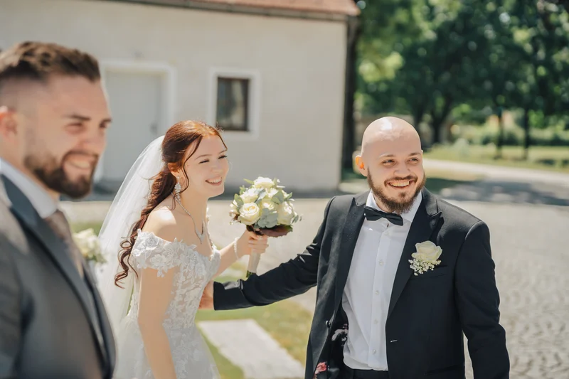 RawmanPictures - Sebastian Schiefermayr | Hochzeit Natalia & Jürgen | Fröhliche Hochzeitsfeier im Freien, Brautpaar lachen, sonniger Tag, romantische Atmosphäre.