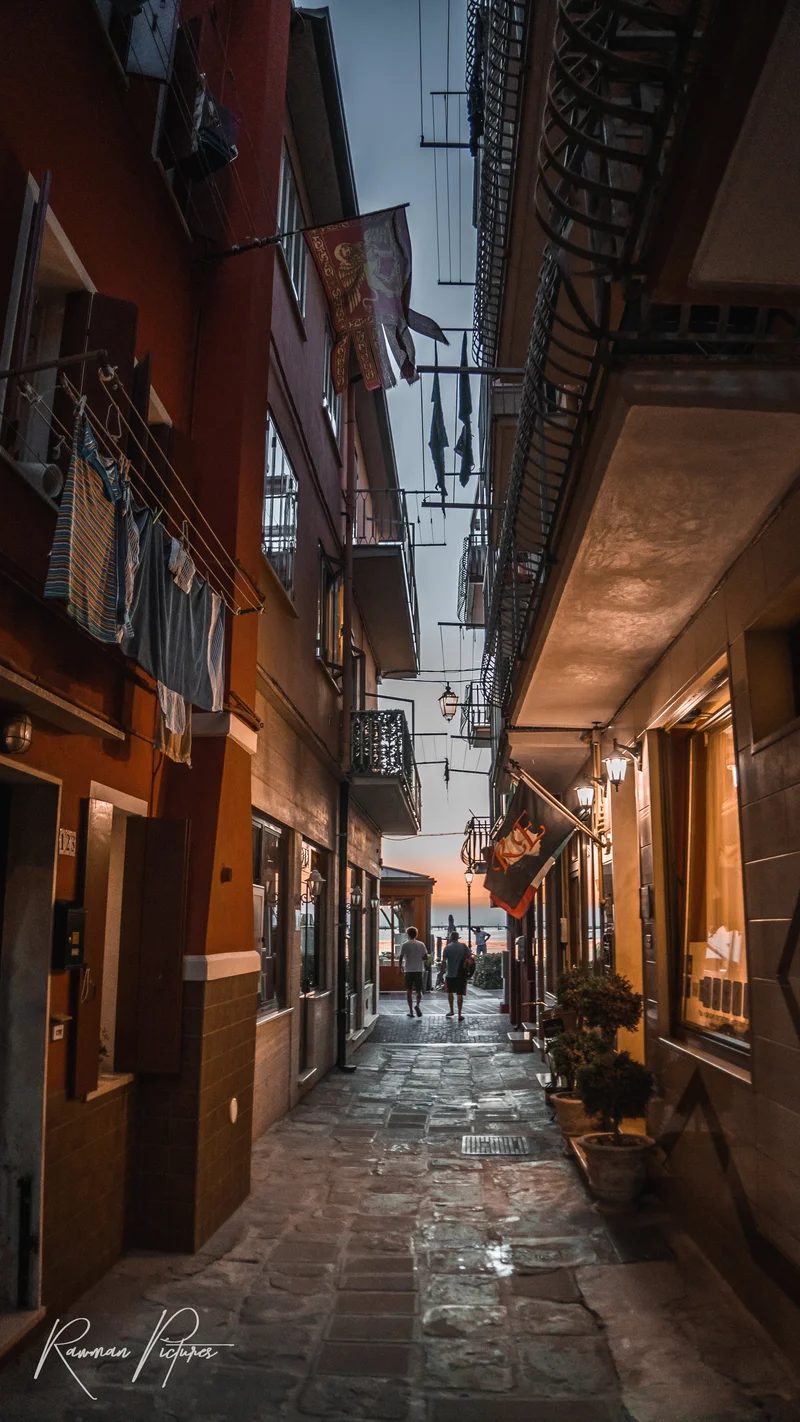 RawmanPictures - Sebastian Schiefermayr | Chioggia 2022 | Enge Gasse bei Sonnenuntergang mit Wäsche und Laternen, stimmungsvolle Stadtfotografie.