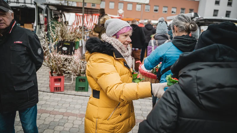 RawmanPictures - Sebastian Schiefermayr | Valentinsaktion Marchtrenk | Besucher auf einem belebten Wochenmarkt im Winter, Marktstände, Outdoor-Fotografie.