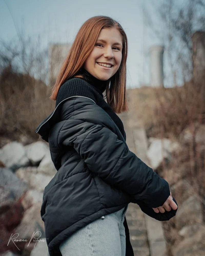 RawmanPictures - Sebastian Schiefermayr | Shooting Lea P. | Junge Frau lächelt im Freien: Porträtfotografie mit natürlichem Hintergrund.