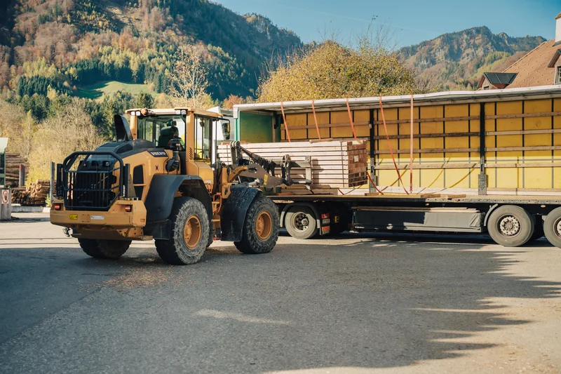 RawmanPictures - Sebastian Schiefermayr | Sägewerk Löberbauer | Radlader beim Verladen von Baumaterialien in malerischer Berglandschaft. Transportfotografie.