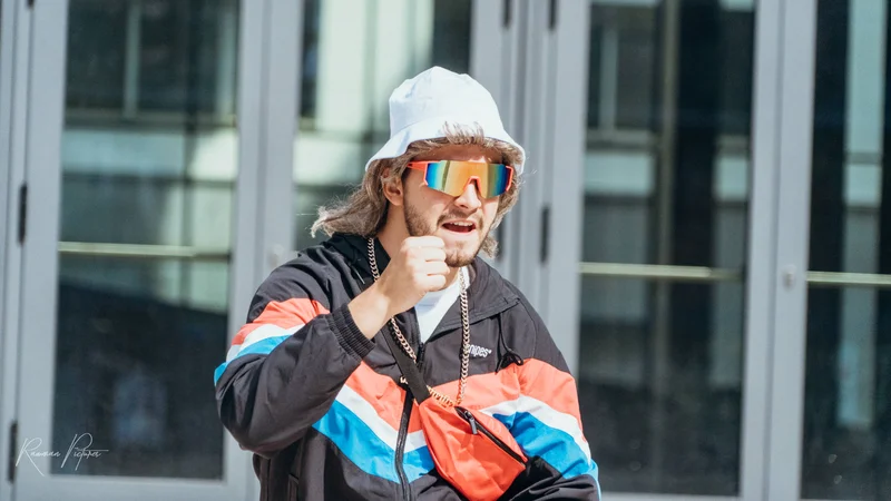 RawmanPictures - Sebastian Schiefermayr | Musikvideodreh "Flinz Asozial" | Moderner urbaner Streetstyle, bunte Sonnenbrille, modisches Outfit, lebendige Straßenfotografie.