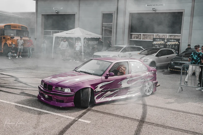 RawmanPictures - Sebastian Schiefermayr | Russnsoda Summer Closing | Drift-Event-Fotografie: Lila BMW bei aufregendem Driftrennen vor staunendem Publikum.
