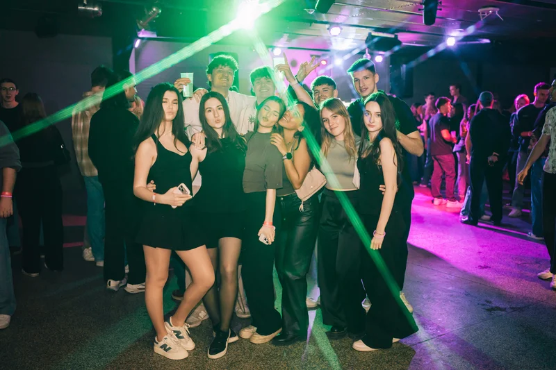 RawmanPictures - Sebastian Schiefermayr | JKU Mensafest | Gruppe junger Menschen auf energiegeladener Party, Tanzfläche, Nachtclub, bunte Lichter.
