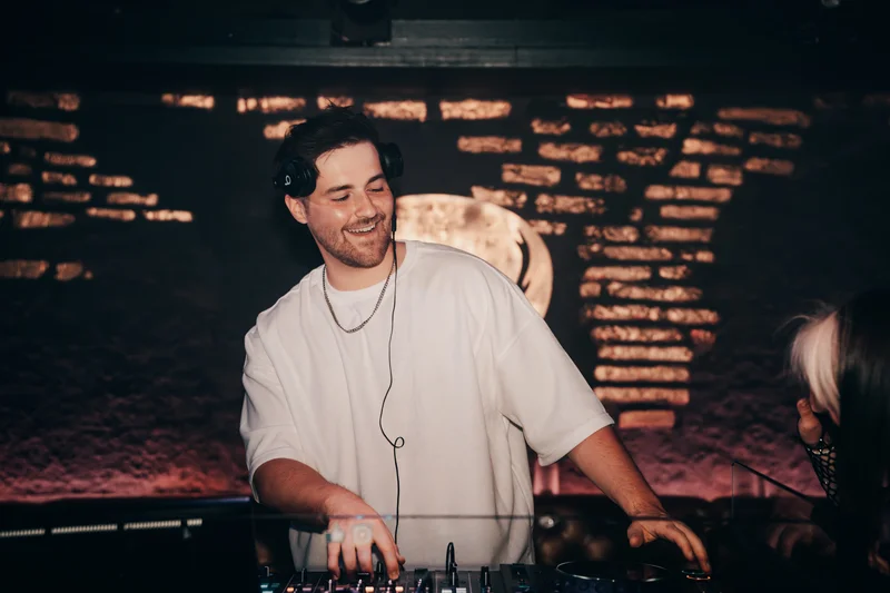 RawmanPictures - Sebastian Schiefermayr | AMP'D Drum & Bass | DJ im Club mit Kopfhörern, elektronische Musik, Nachtleben-Fotografie, Party-Vibes.