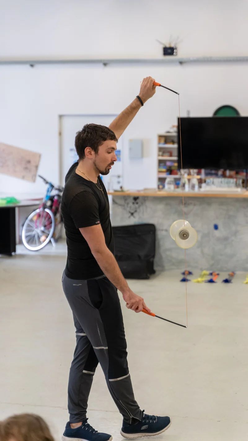 RawmanPictures - Sebastian Schiefermayr | Jonglierworkshop Marchtrenk | Mann spielt mit Diabolo im Studio, dynamische Actionfotografie.