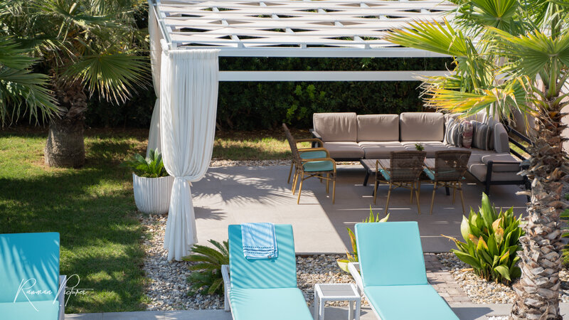 RawmanPictures - Sebastian Schiefermayr | Maturareise Kroatien | Gartenfotografie: Stilvolles Outdoor-Wohnzimmer mit eleganten Möbeln und Pergola.
