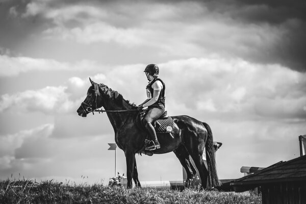 RawmanPictures - Sebastian Schiefermayr | Vielseitigkeits­turnier | Schwarz-Weiß-Fotografie, Reiter auf Pferd vor dramatischem Himmel, Outdoor-Sport, Equine-Porträt.