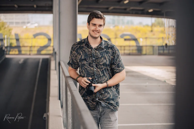 RawmanPictures - Sebastian Schiefermayr | Personal Shooting | Fotograf auf Parkdeck mit Kamera, ideal für natürliche Porträts und urbane Fotografie.