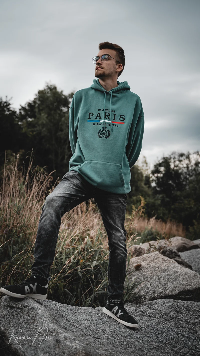 RawmanPictures - Sebastian Schiefermayr | Shooting Philipp B. | Mann in stylischem Hoodie posiert im Freien, Markenmode, Outdoor-Fotografie, kreative Porträts.