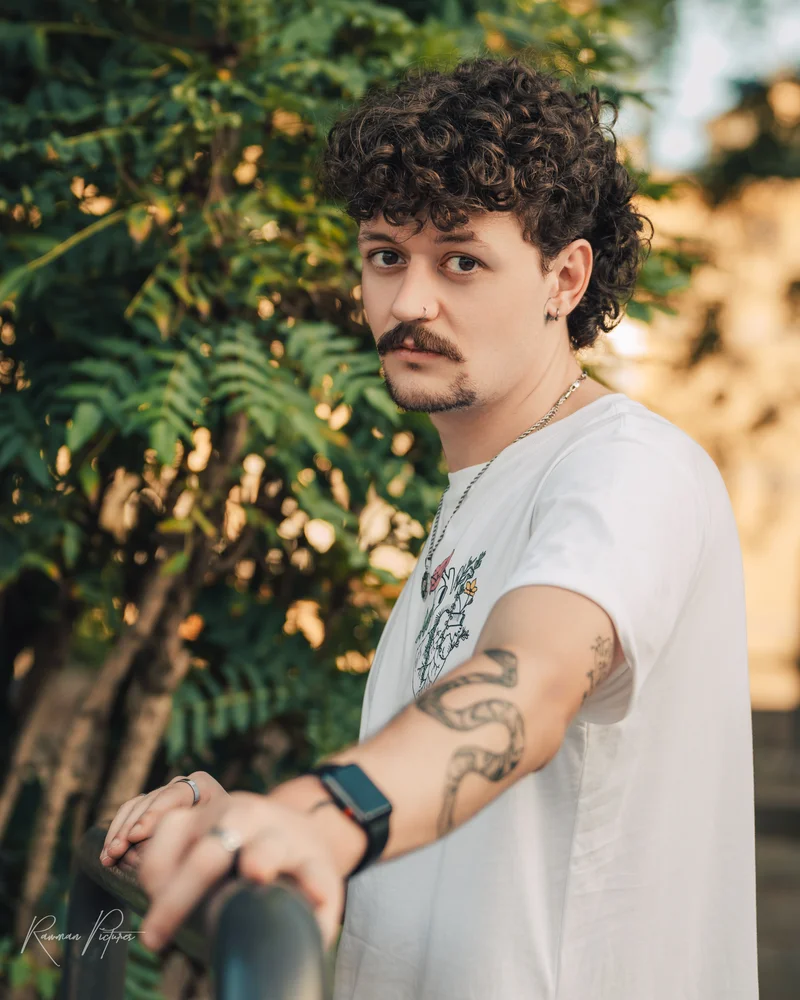 RawmanPictures - Sebastian Schiefermayr | Urlaub Jesolo | Portraitfotografie im Freien, Mann mit lockigem Haar, Tattoos, natürlicher Hintergrund.