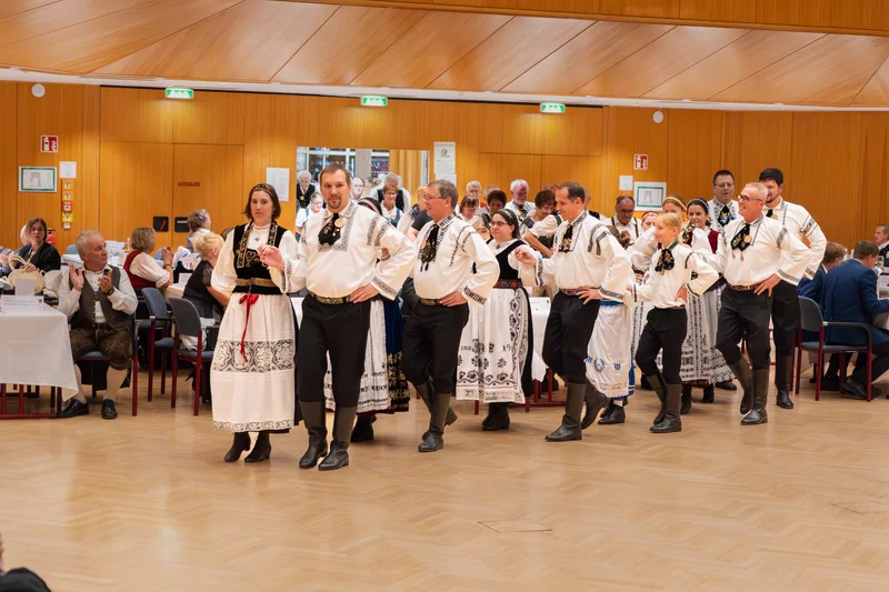 RawmanPictures - Sebastian Schiefermayr | Volkstanzfest | Traditionelle Volkstanzaufführung in Trachten, festlich dekorierter Saal, Kulturveranstaltung.