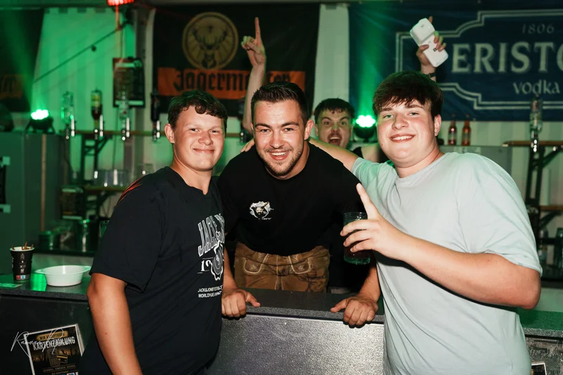 RawmanPictures - Sebastian Schiefermayr | Stadtfest-Marchtrenk  | Gruppe feiert fröhlich in der Bar. Eventfotografie, lebendige Nachtaufnahme, Partyszene.