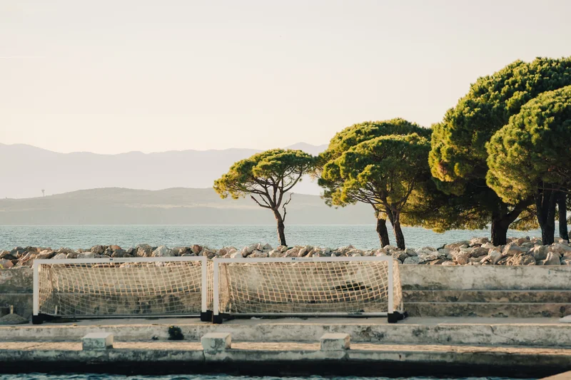 RawmanPictures - Sebastian Schiefermayr | Content Trip: Crikvenica 2025 | Küstenlandschaft mit Fußballtor, Bäume und Meer im Hintergrund – perfekte Fotomomente.