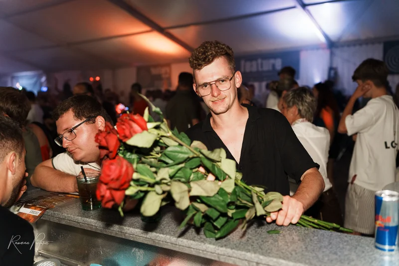 RawmanPictures - Sebastian Schiefermayr | Stadtfest-Marchtrenk  | Mann mit Rosen in Festivalzelt, Nachtfotografie, Eventfotografie, stimmungsvolle Beleuchtung.