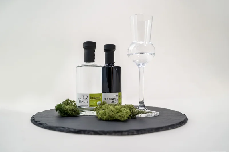 RawmanPictures - Sebastian Schiefermayr | Kräuter­manufaktur Sallmannsberg | Stilvolle Produktfotografie: Edle Spirituosen und Glas auf Schieferplatte.