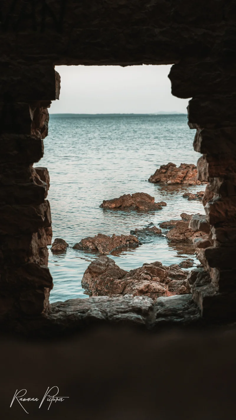 RawmanPictures - Sebastian Schiefermayr | Maturareise Kroatien | Meerblick durch Steintor: Küste, Felsen, ruhiges Wasser. Perfect für Landschaftsfotografie.