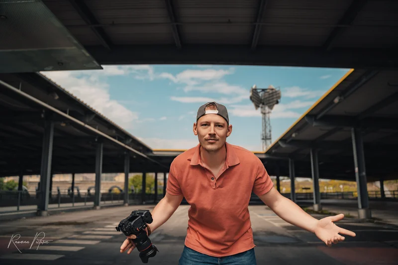 RawmanPictures - Sebastian Schiefermayr | Personal Shooting | Moderner Outdoor-Porträtfotograf mit Kamera auf urbanem Parkdeck. Fotografie-Experte.