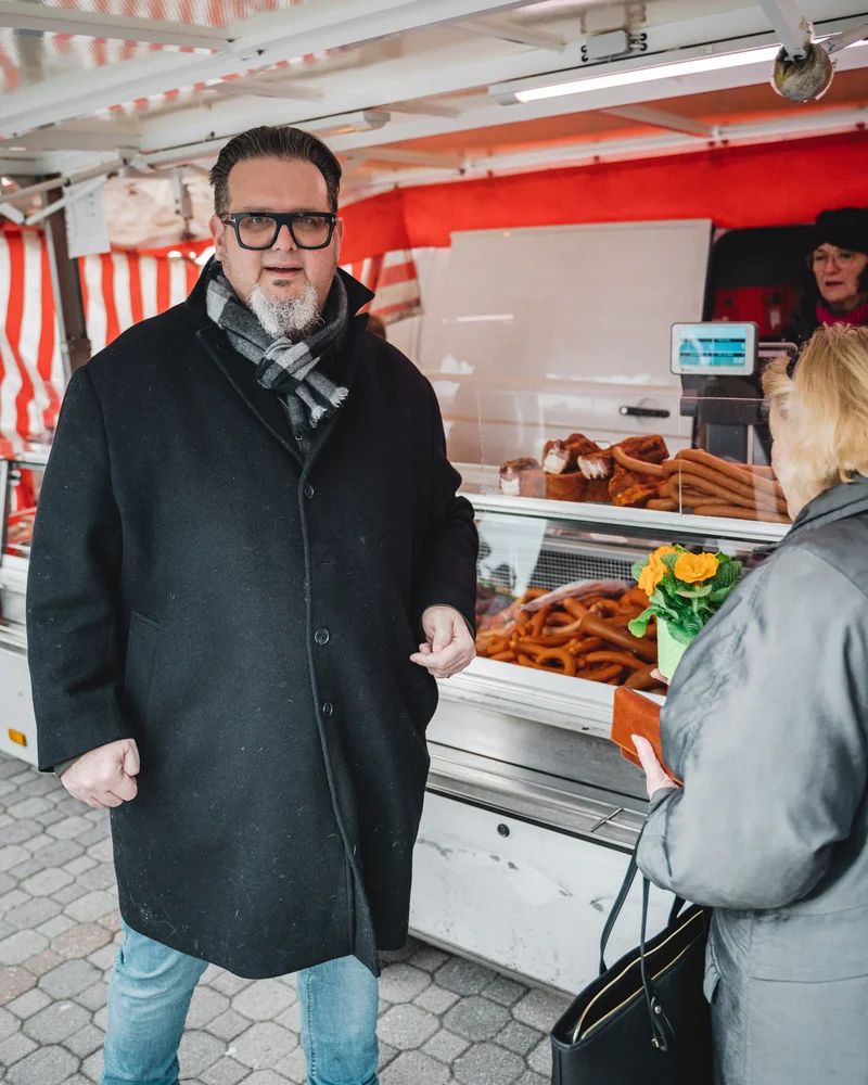 RawmanPictures - Sebastian Schiefermayr | Valentinsaktion Marchtrenk | Kunden am Markstand: Authentische Momentaufnahme lokaler Marktbesuche. Ideal für Street-Fotografie.