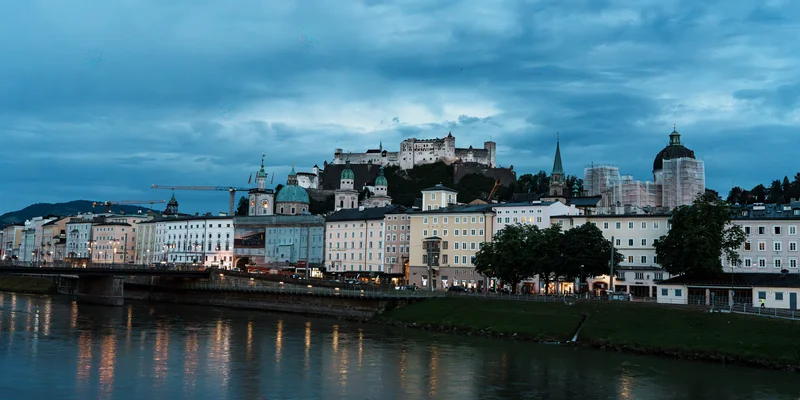 RawmanPictures - Sebastian Schiefermayr | Contentday Salzburg | Abendstimmung in Salzburg: Historische Architektur und Flussufer. Perfekt für Stadtfotografie.