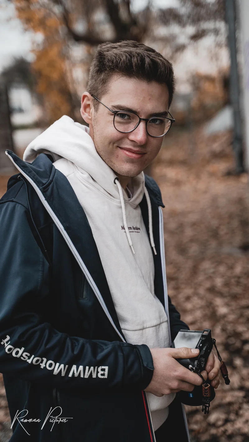RawmanPictures - Sebastian Schiefermayr | Shooting Julian S. | Porträt eines jungen Fotografen im Herbst, lässig mit Kamera, Naturhintergrund.