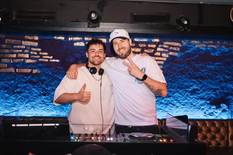 RawmanPictures - Sebastian Schiefermayr | AMP'D Drum & Bass | Zwei DJs im Club vor dem Mischpult, Partyatmosphäre, DJ-Event, Musikfotografie.