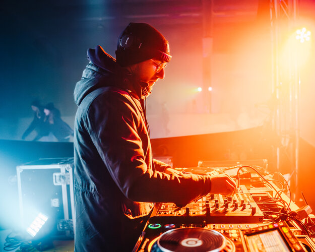 RawmanPictures - Sebastian Schiefermayr | Eisdisco Marchtrenk | DJ bei Nacht Veranstaltung, bunte Lichter, dynamische Clubatmosphäre, Musikfotografie.