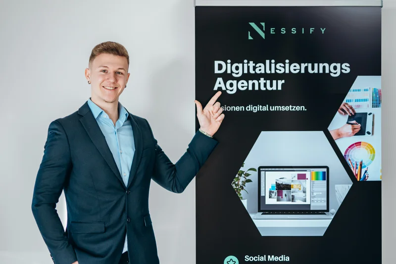 RawmanPictures - Sebastian Schiefermayr | Bussines-Shooting Nessify | Mann präsentiert Digitalisierungsagentur-Plakat in einem Büroumfeld für Marketingfotografie.