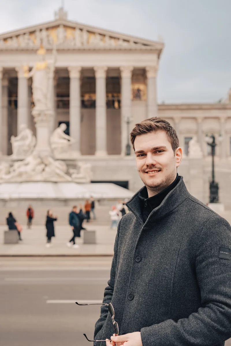RawmanPictures - Sebastian Schiefermayr | Daytrip Wien | Mann vor historischer Architektur: Zeitlose Eleganz und urbaner Charme in perfektem Einklang.