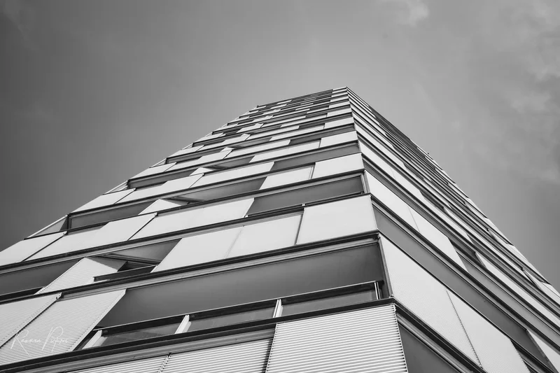 RawmanPictures - Sebastian Schiefermayr | Urlaub Jesolo | Moderne Architektur: Hochhaus-Fotografie in Schwarz-Weiß, Perspektive von unten nach oben.