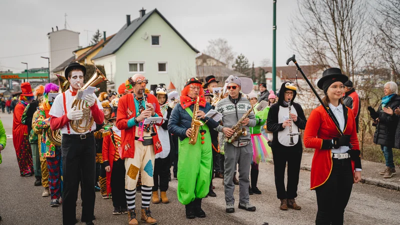 RawmanPictures - Sebastian Schiefermayr | Faschingsumzug Weißkirchen | Karnevalsumzug mit kostümierten Musikern und fröhlicher Atmosphäre auf einer Straße.