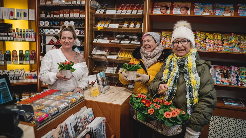 RawmanPictures - Sebastian Schiefermayr | Valentinsaktion Marchtrenk | Drei Personen in einem gemütlichen Laden, lächelnd mit Blumen in der Hand.