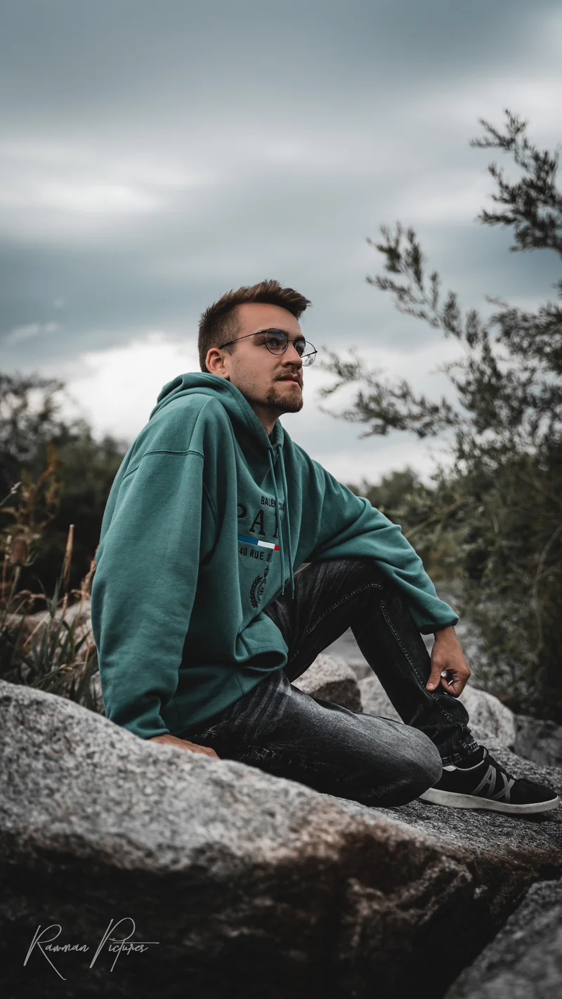 RawmanPictures - Sebastian Schiefermayr | Shooting Philipp B. | Outdoor-Porträtfotografie, Mann entspannt auf Felsen in natürlicher Kulisse.