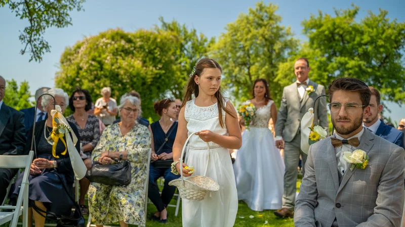 RawmanPictures - Sebastian Schiefermayr | Hochzeit Traude & Gerhard | Außenhochzeitszeremonie: Blumenkind schreitet den Gang entlang. Festliche Momente im Freien.