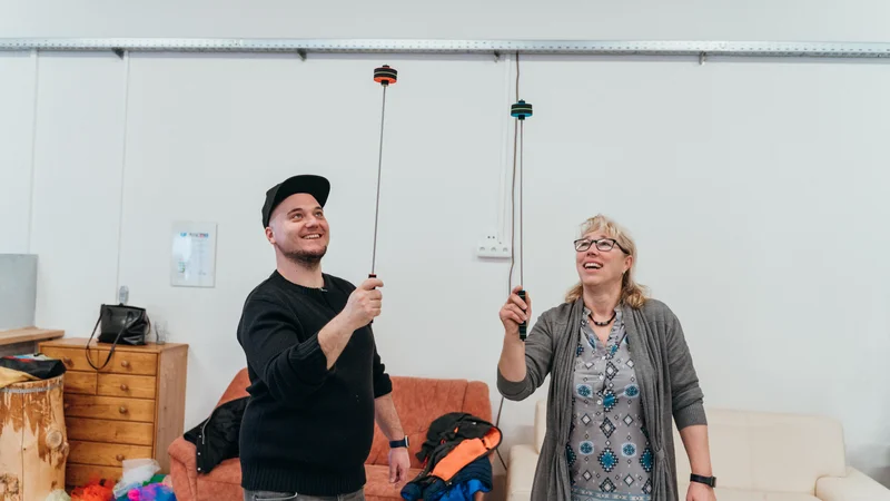 RawmanPictures - Sebastian Schiefermayr | Jonglierworkshop Marchtrenk | Zwei Personen genießen das Jonglieren in einem hellen Raum. Freizeitaktivität, Ausdruck von Freude.