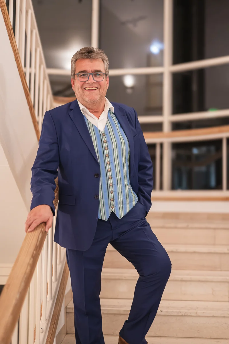 RawmanPictures - Sebastian Schiefermayr | Volkstanzfest | Eleganter Herrenanzug auf Treppe im Innenbereich für Portraitfotografie.