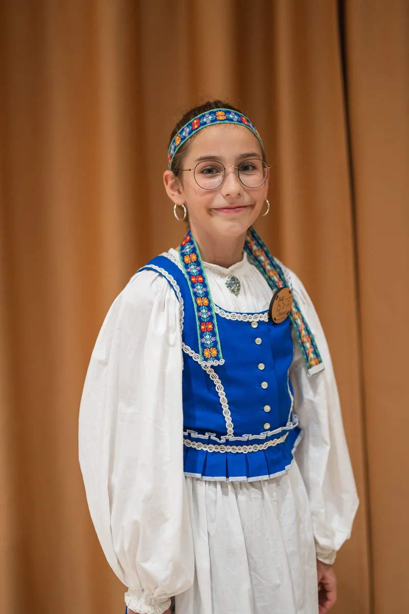 RawmanPictures - Sebastian Schiefermayr | Volkstanzfest | Mädchen in traditioneller Tracht vor beigem Hintergrund. Kulturelle Portraitfotografie.