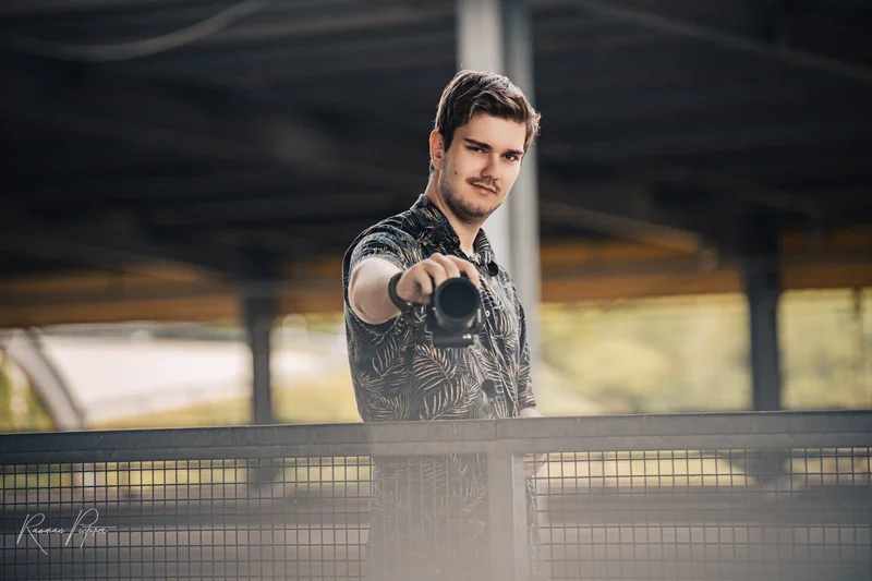 RawmanPictures - Sebastian Schiefermayr | Personal Shooting | Fotograf mit Kamera in urbaner Umgebung, modernes Portrait für Werbezwecke.