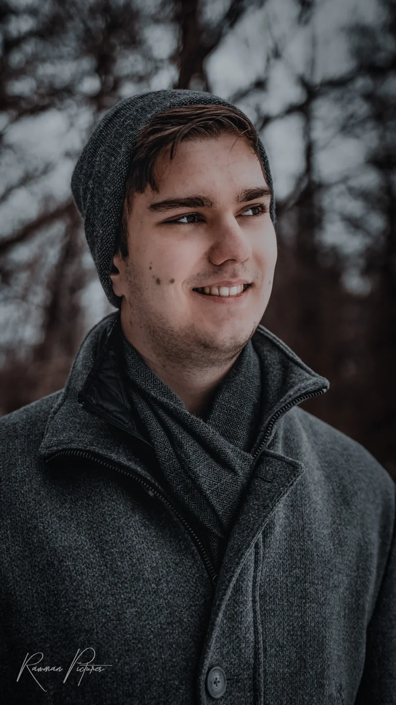 RawmanPictures - Sebastian Schiefermayr | Wintershooting Maximilian W. | Portrait eines jungen Mannes im Wintermantel, Outdoor-Fotografie, natürlicher Hintergrund.