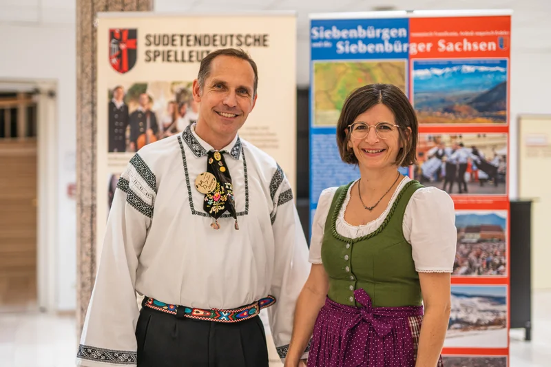 RawmanPictures - Sebastian Schiefermayr | Volkstanzfest | Lächelnde Menschen in traditioneller Tracht auf einer Kulturveranstaltung.