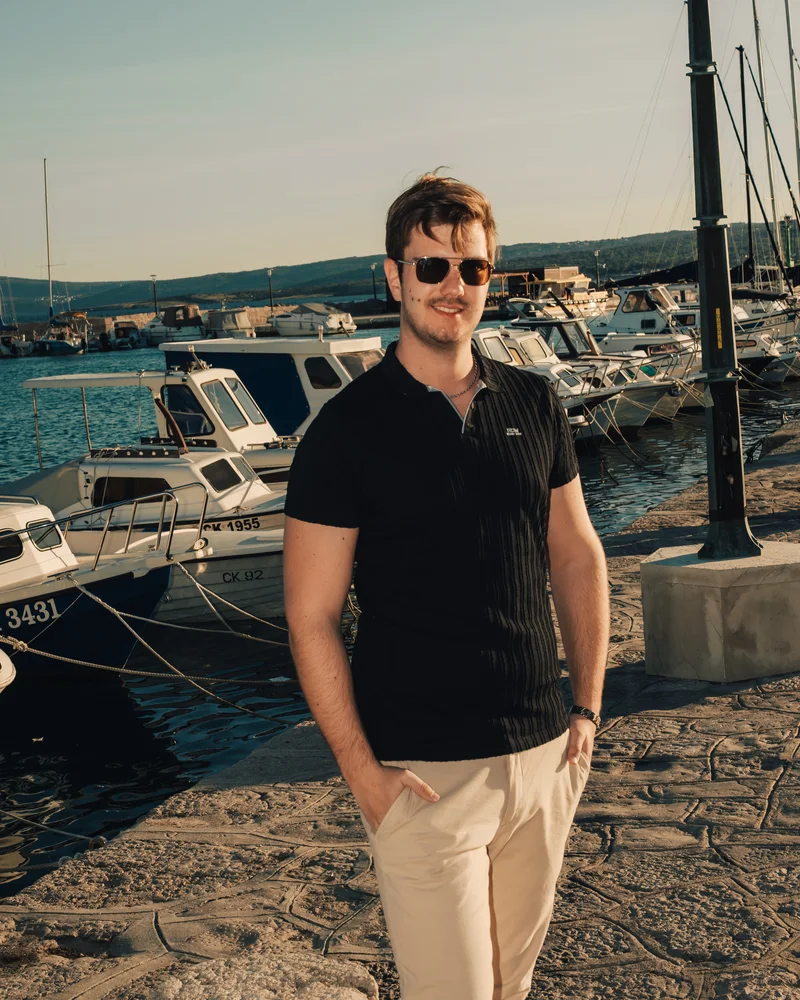 RawmanPictures - Sebastian Schiefermayr | Content Trip: Crikvenica 2025 | Mann im Hafen mit Sonnenbrille, stilvolle Fotografie am Wasser bei Sonnenuntergang.