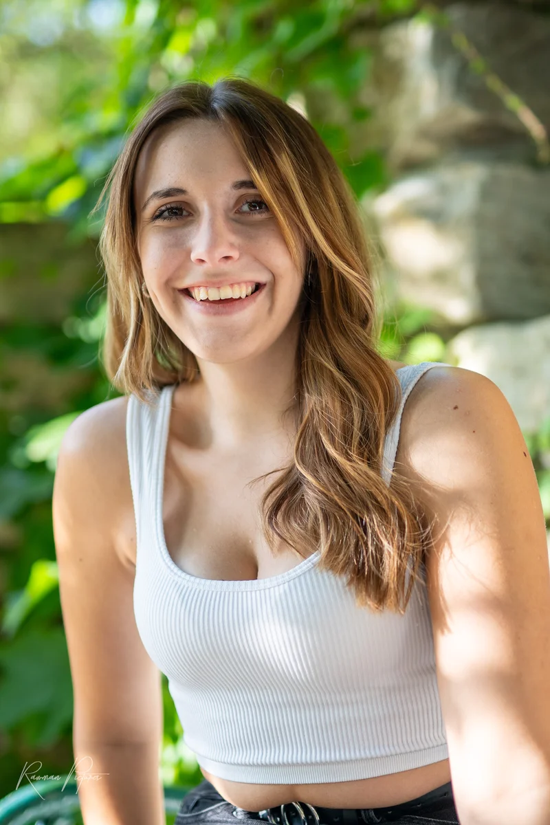 RawmanPictures - Sebastian Schiefermayr | Shooting Sophie N. | Junge Frau lächelnd im Garten, natürliche Porträtfotografie mit weichem Lichteinfall.