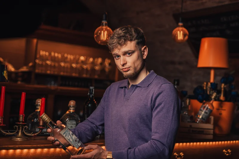 RawmanPictures - Sebastian Schiefermayr | Portraitshooting Kevin F. | Bar-Mood-Porträt: Stilvolle Beleuchtung, urbaner Flair, Bartender-Präsentation, stimmungsvolle Atmosphäre.