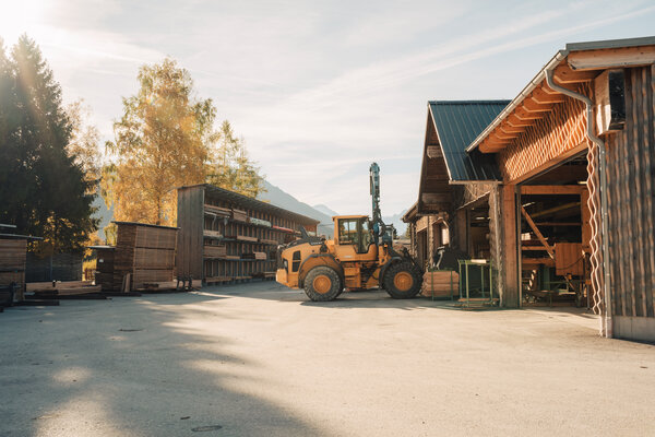 RawmanPictures - Sebastian Schiefermayr | Sägewerk Löberbauer | Holzlager im Freien mit Gabelstapler bei Sonnenuntergang, Bau- und Lagerlogistik.