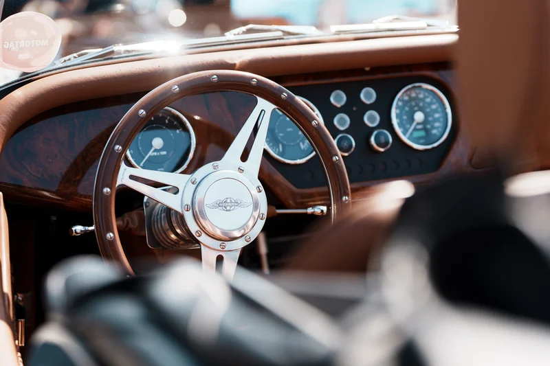 RawmanPictures - Sebastian Schiefermayr | Motortag 2026 | Innenraum eines klassischen Autos, Fokus auf Lenkrad. Vintage Autointerieur, Retro-Design.