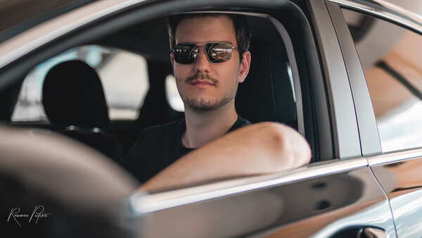 RawmanPictures - Sebastian Schiefermayr | Personal Shooting | Mann im Auto mit Sonnenbrille und entspanntem Ausdruck. Ideal für professionelle Autofotografie.