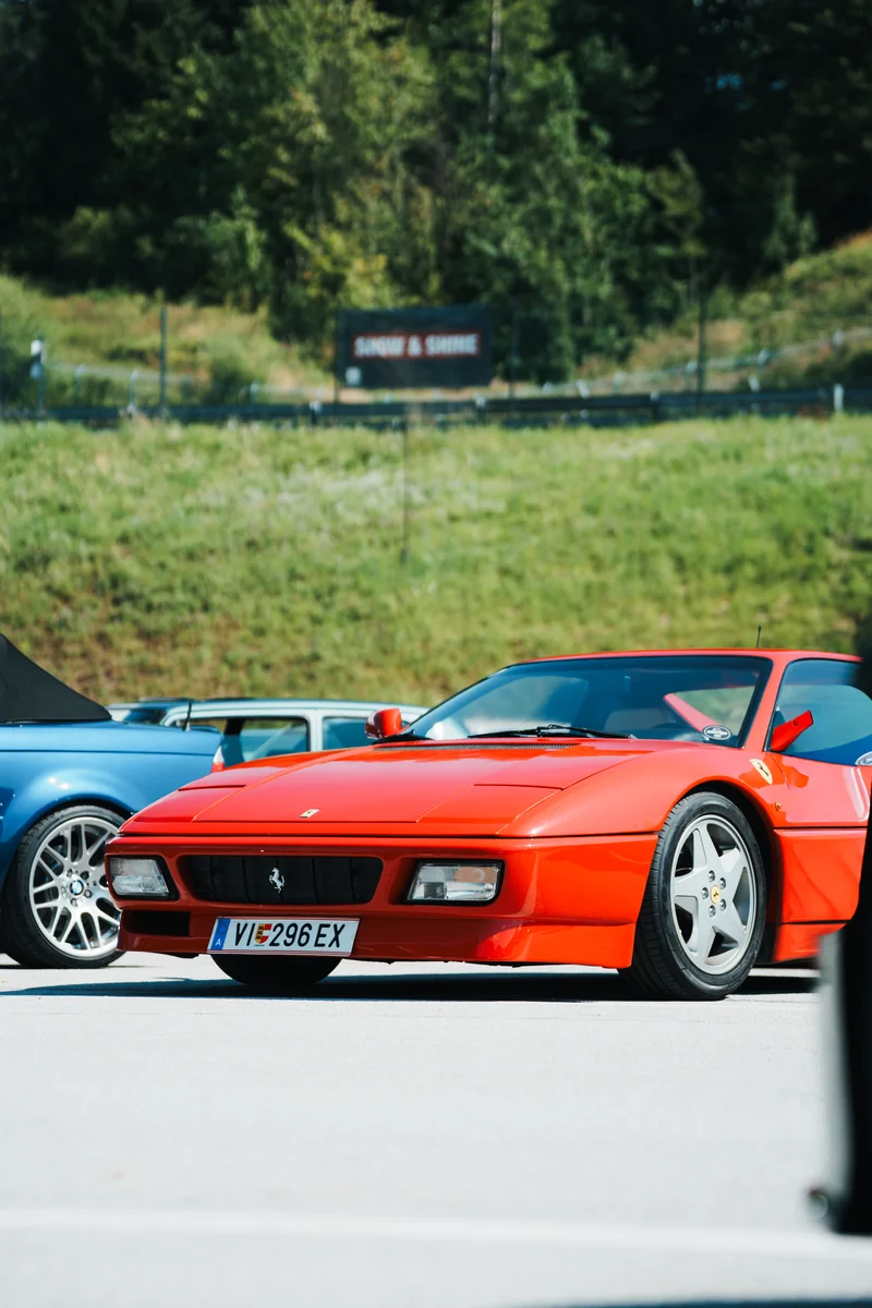 RawmanPictures - Sebastian Schiefermayr | Motortag 2026 | Roter Sportwagen auf Ausstellungsfläche bei Sonnenschein, perfekte Wahl für Auto-Enthusiasten.